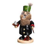 Eine traditionelle erzgebirgische Räucherfigur eines Bergmanns. Er trägt einen schwarzen Mantel mit rotem Kragen und Ärmeln und einen grünen Hut mit gekreuzten Spitzhacken. Er hat einen langen, grauen Bart und buschige Augenbrauen. In seiner linken Hand hält er ein silbernes Erzstück und in seiner rechten Hand eine schwarze Spitzhacke. Er steht auf einem kleinen Holzsockel mit einem roten und grünen Tannenzweig und einem kleinen Amboss.